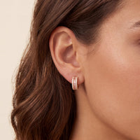 Gold huggie hoop earrings with pink baguette morganite stones and sparkle accents