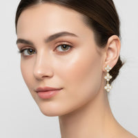 Mother-of-pearl clover triple-drop earrings in gold, worn near the ear