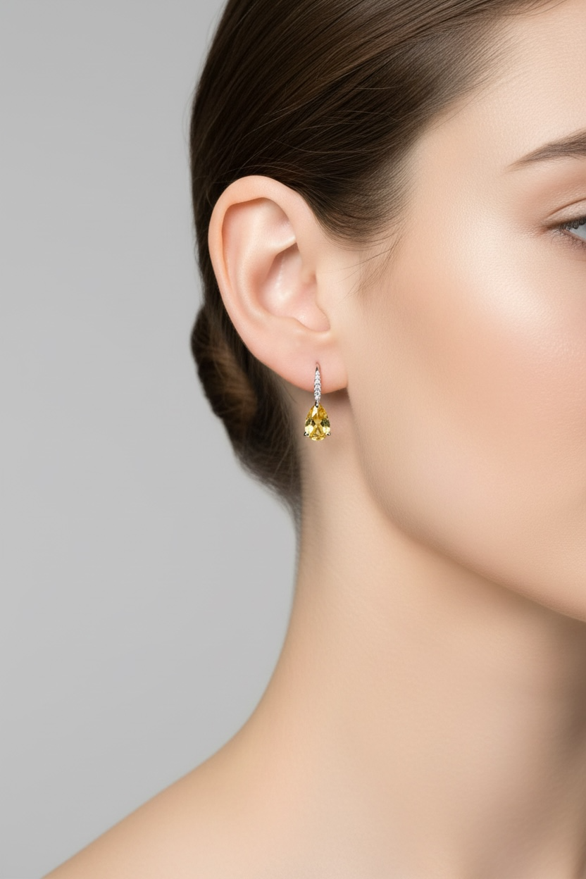 Teardrop earrings with yellow topaz dangling from a woman&