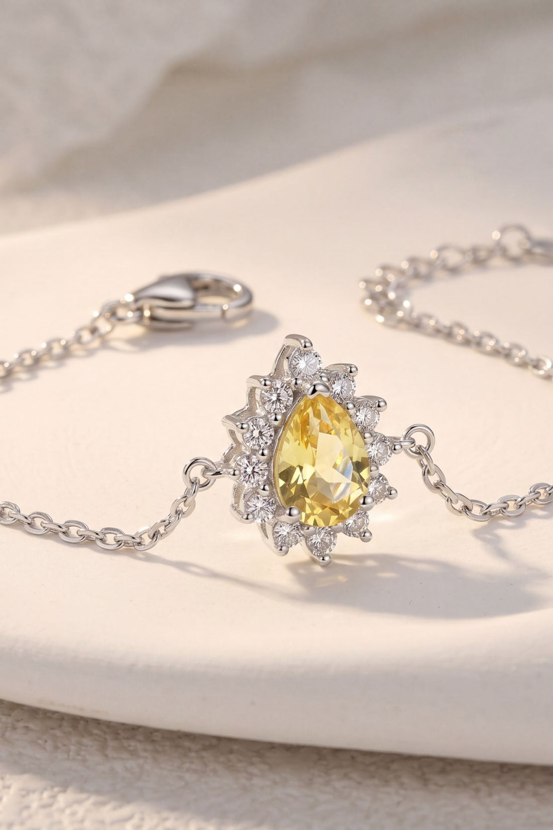 Silver bracelet close-up with oval yellow center stone and crystal halo