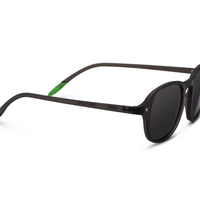 Three-quarter view of dark tinted sunglasses with black frame and green temple accents