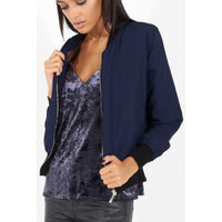 Navy women’s bomber jacket with zip front, ribbed cuffs, and black-trim hem