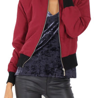 Burgundy women’s bomber jacket with zip front, ribbed cuffs, and black waistband trim