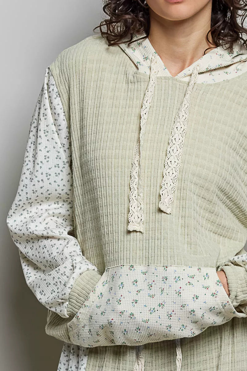 Sage mixed-knit contrast print sleeve hoodie close-up with hood drawstrings and kangaroo pocket