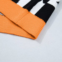 Black checkerboard ghost sweater with orange ribbed hem