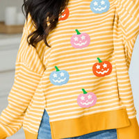 Yellow striped Halloween pullover with colorful pumpkin faces and drop-hem panel