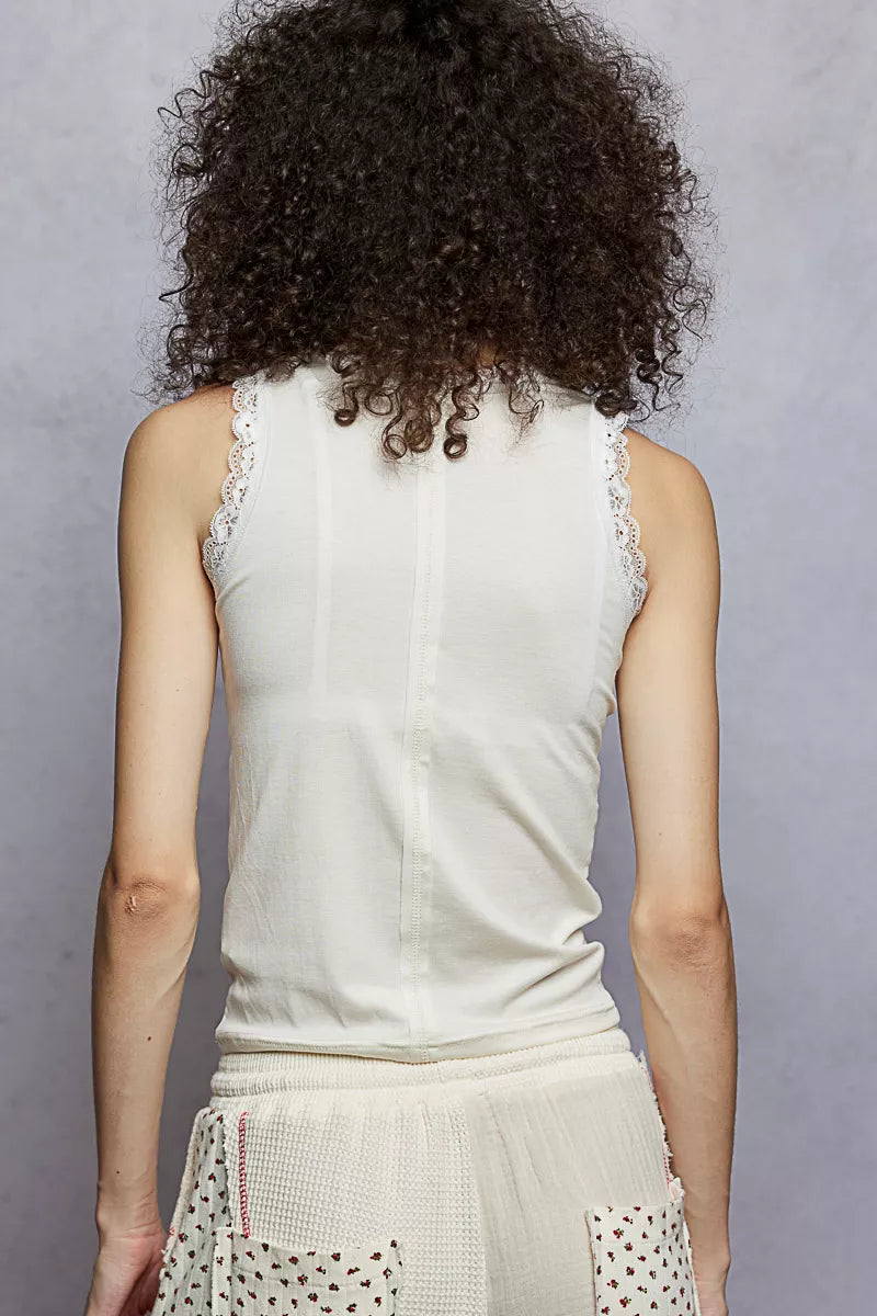 Cream cropped tank top with round neck and lace trim at neckline and armholes