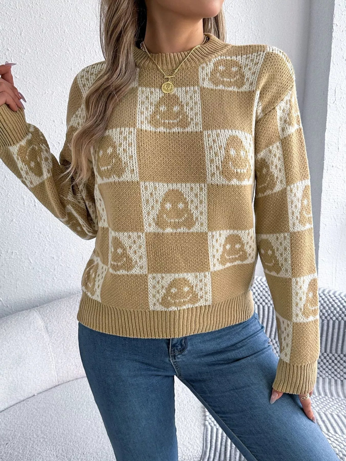 Ghost-pattern checkered round-neck sweater in tan and cream, front view.