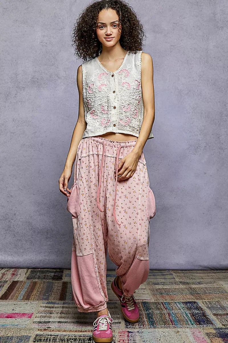 Floral embroidered V-neck sleeveless vest in cream with pink flower motifs and buttons.