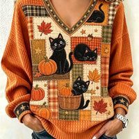 Orange V-neck sweater with black cats, pumpkins, and fall leaf patchwork front