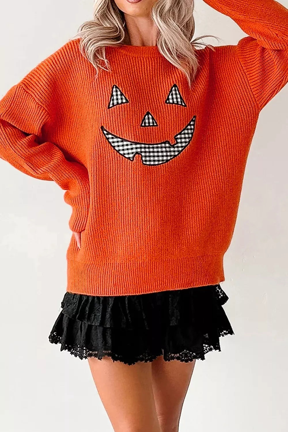 Orange knit sweater with jack-o-lantern print, long sleeves and round neckline