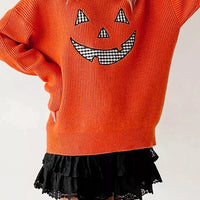 Orange knit sweater with jack-o-lantern print, long sleeves and round neckline
