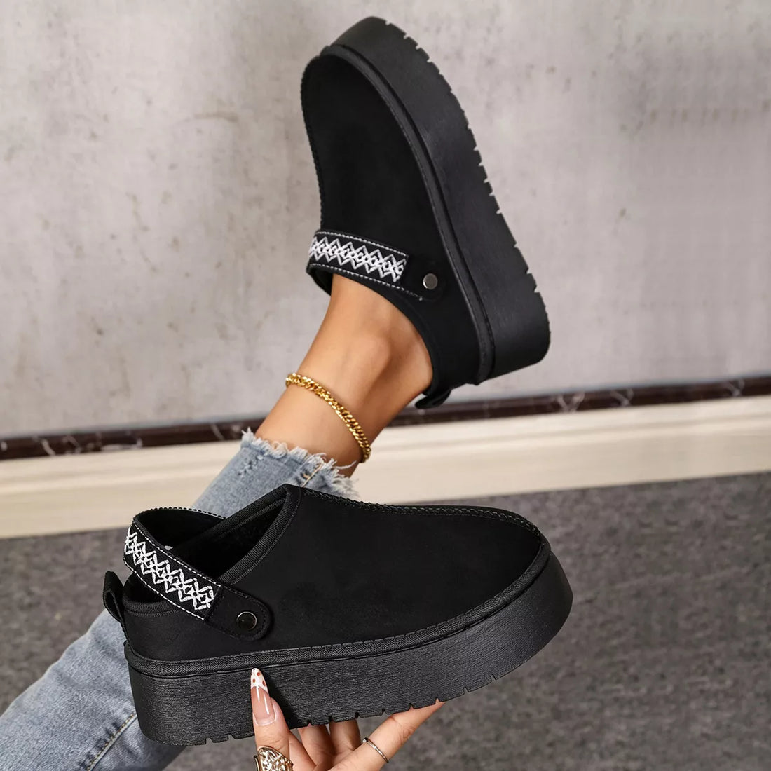 Black suede fur-lined platform boots with pull tab, stitched cuff, and thick sole.