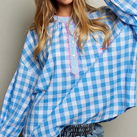 Blue gingham blouse with pink embroidered front placket and palm motif on pocket