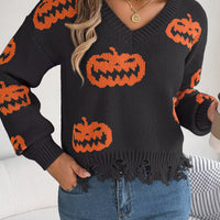 Black knit V-neck sweater with orange jack-o’-lantern motifs and distressed frayed hemline