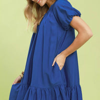 Blue shift mini dress with gathered waist and ruffle hem, side view.
