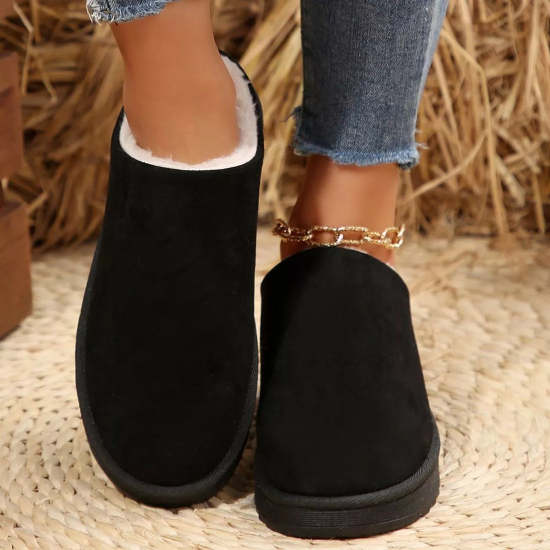 Pair of black plush lined ankle boots with round toe, back view of cushioned collar.