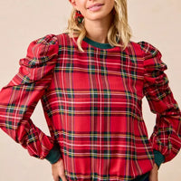 Red plaid top with exaggerated shoulders, balloon sleeves, and green ribbed hem