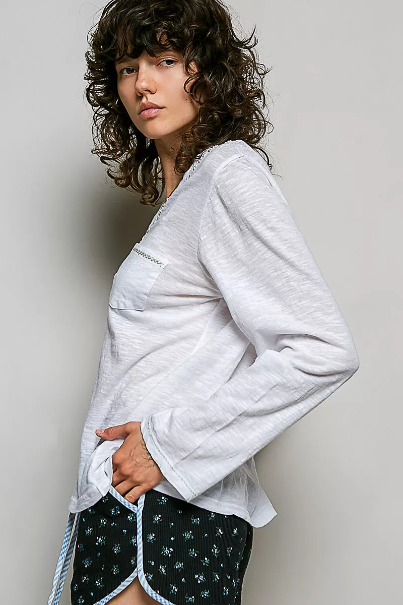 Off white long-sleeve knit V-neck top with contrast trim and chest pocket, side view.