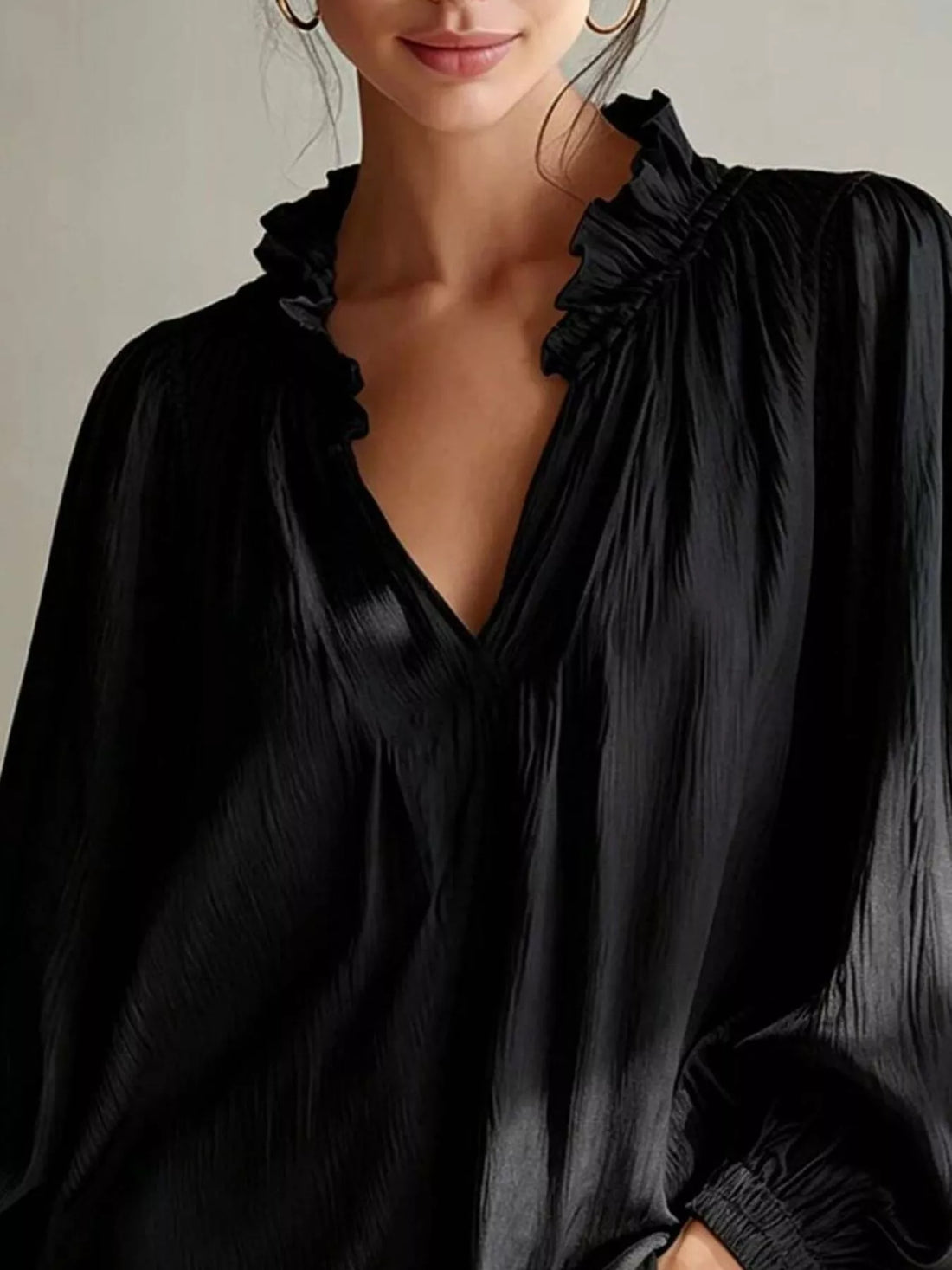 Black ruffle-trim blouse with V-neck and shoulder ruffle detailing