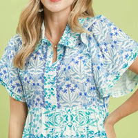 Close-up of blue floral tiered mini dress with flutter sleeves and collar