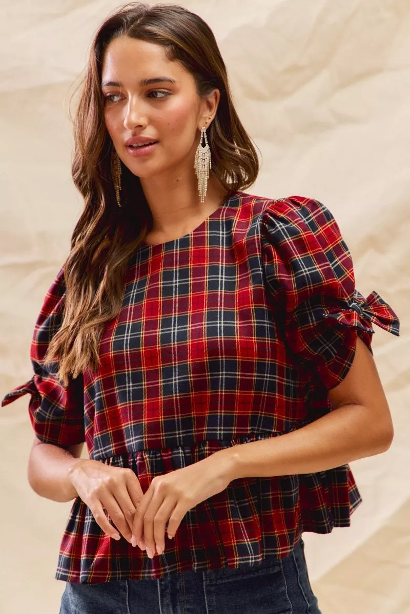 Red plaid peplum top with ribbon-tied puff sleeves and gathered waist