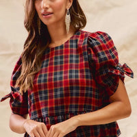 Red plaid peplum top with ribbon-tied puff sleeves and gathered waist