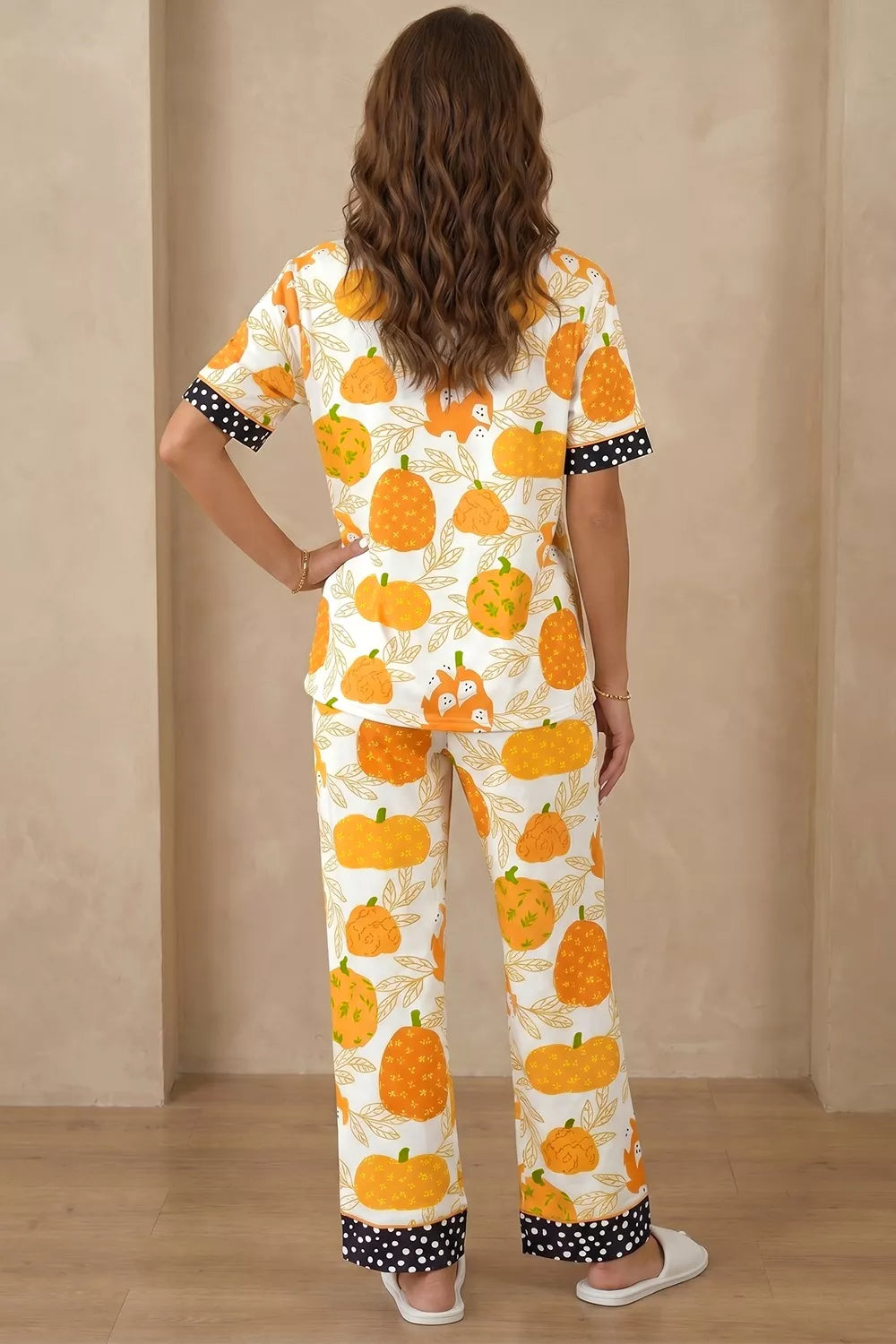Back view of pumpkin print lounge pajama set with polka-dot trim at collar and cuffs