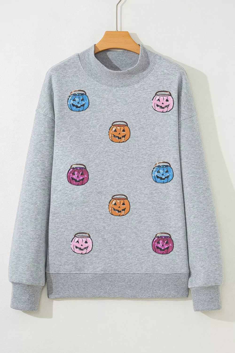 Gray sweatshirt on hanger with pumpkin-face graphic front and ribbed crew neck