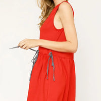 Red sleeveless tank dress with round neck, gathered skirt, and pocket ties