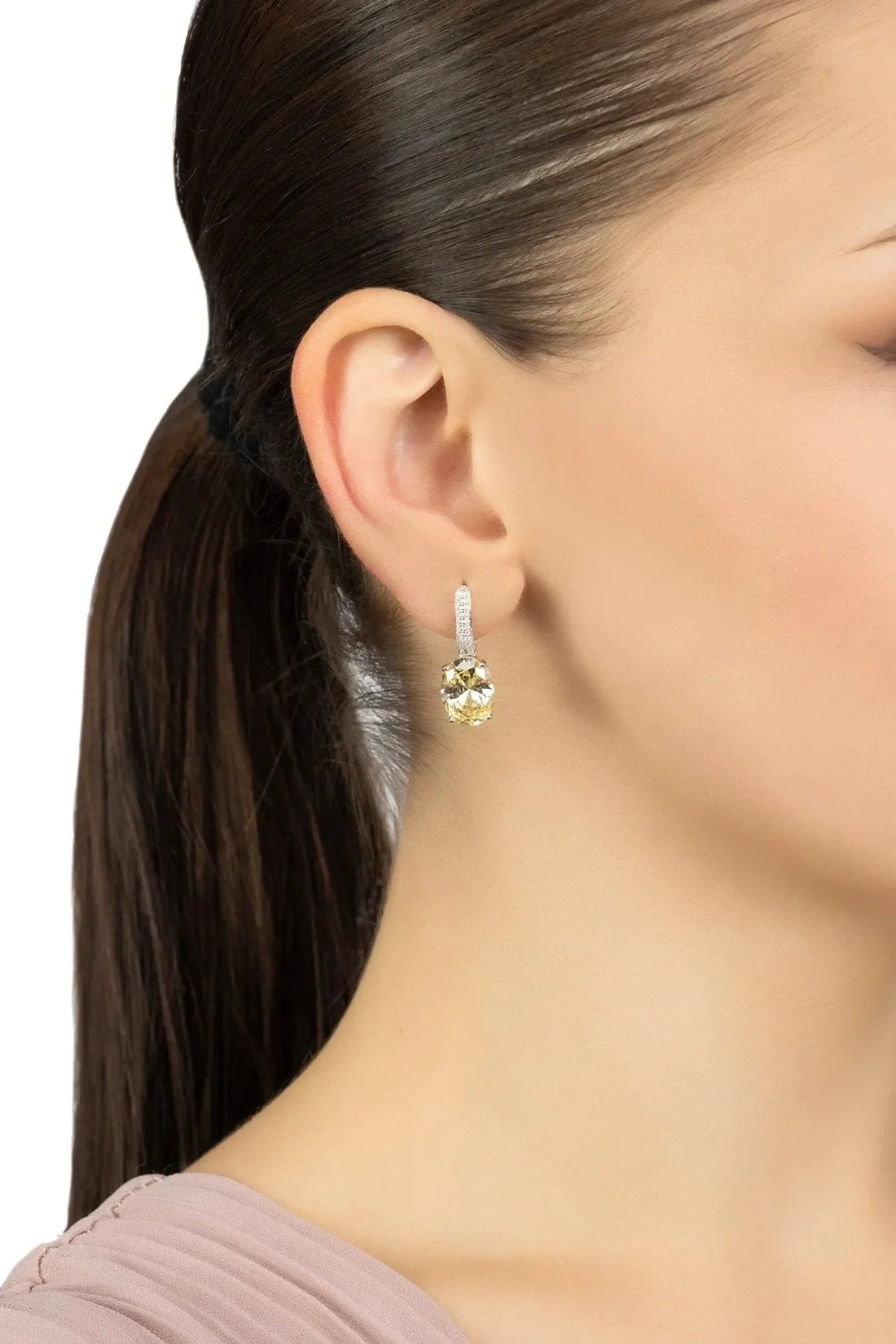 Silver oval drop earrings with yellow topaz, shown being worn on the ear