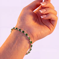 Green heart tennis bracelet on hand, silver chain with emerald-cut stone hearts