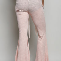 Blush pink textured knit drawstring pants with wide flared legs and inner ties