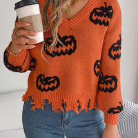 Orange knit V-neck sweater with black pumpkin pattern and fringe-style distressed hem