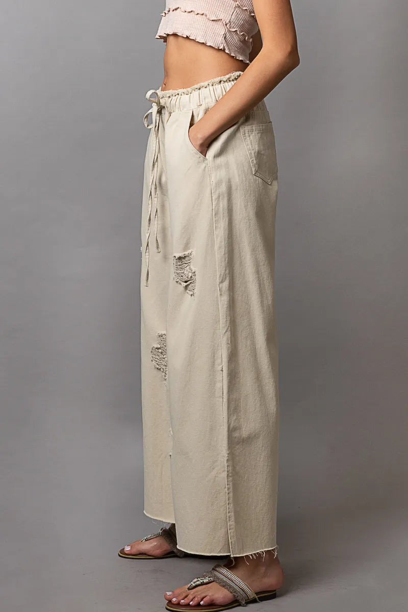 Cream distressed wide-leg pants with drawstring waist and side slit, side view