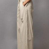 Cream distressed wide-leg pants with drawstring waist and side slit, side view
