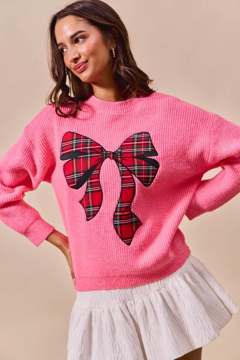 Pink knit sweater with large plaid ribbon bow and tie-like center detail