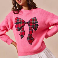 Pink knit sweater with large plaid ribbon bow and tie-like center detail