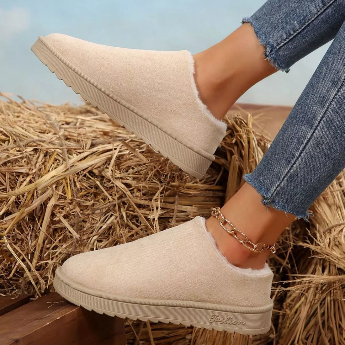 Off-white slip-on ankle boots with plush collar, round toe, outsole sole and stitching.