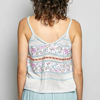 Back view of cream and blue printed cami with V-back straps and decorative trim