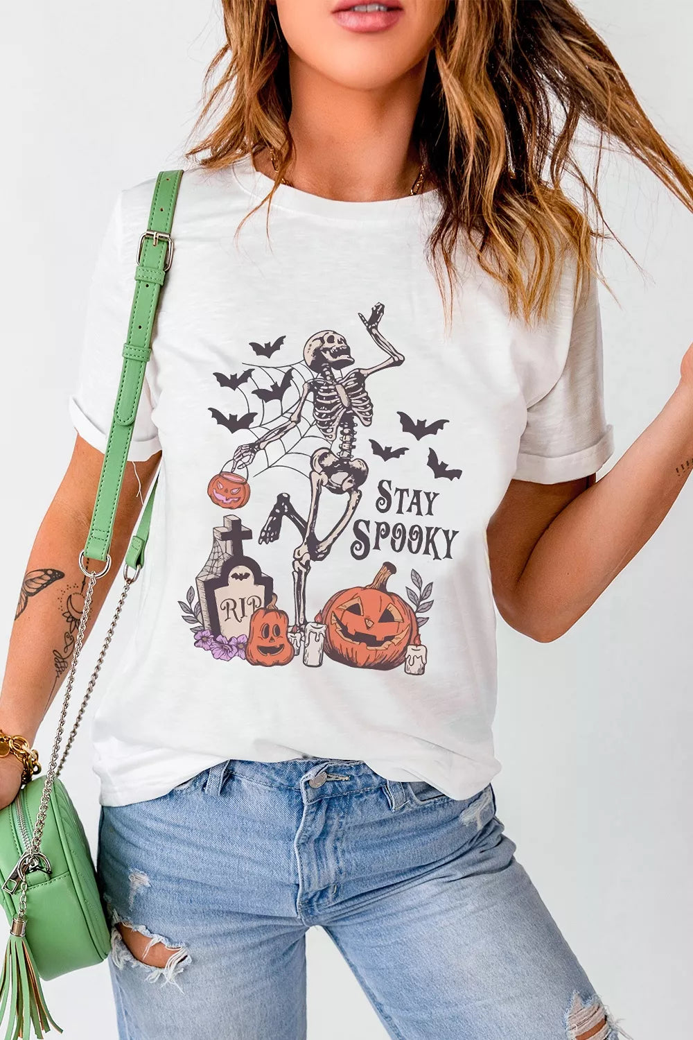 White Halloween graphic T-shirt with skeleton, pumpkins, bats, and &