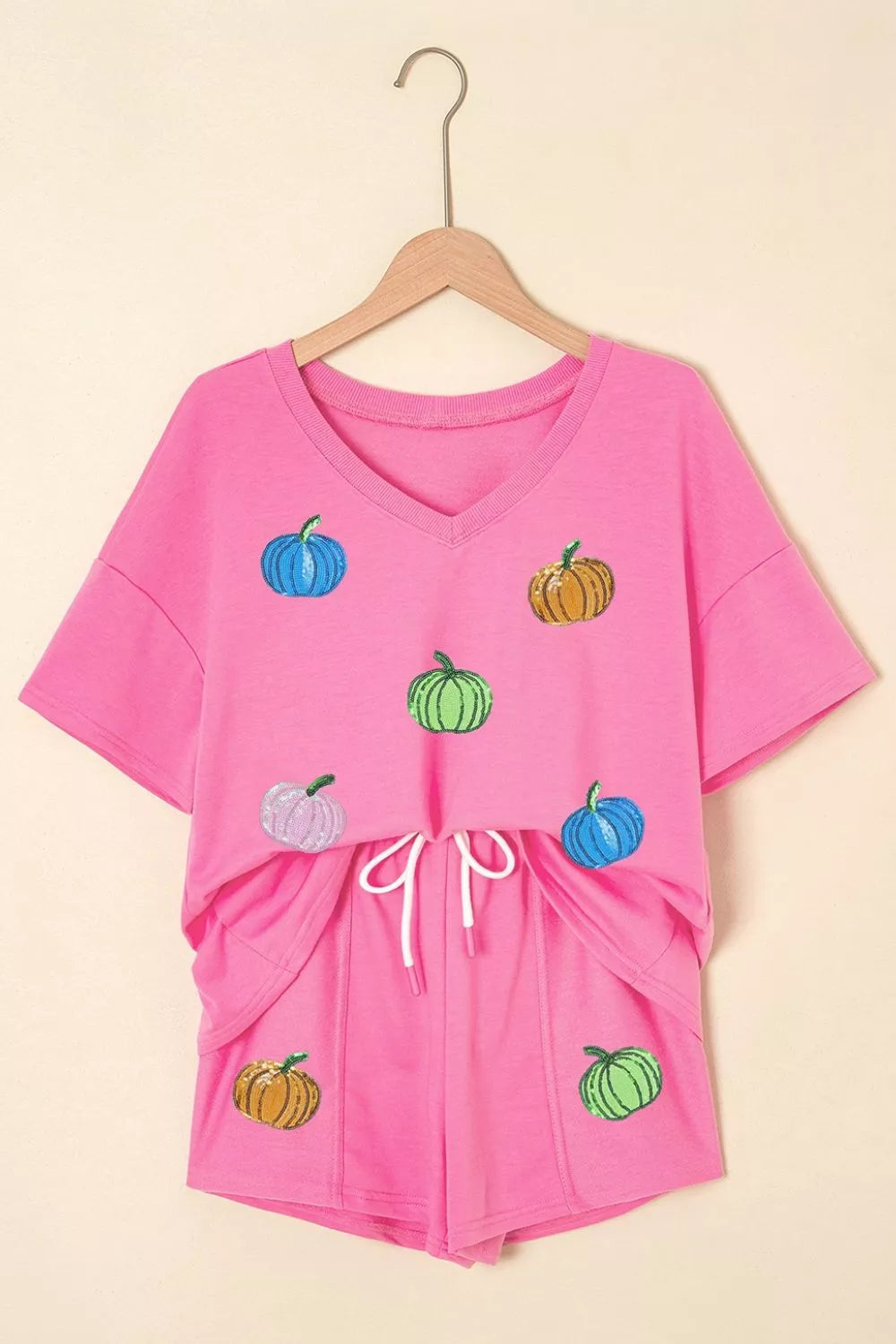 Fuchsia pink V-neck pumpkin print tee and drawstring shorts set on hanger