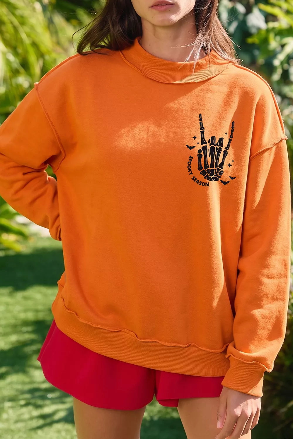 Orange mock neck sweatshirt with skeleton-hand &