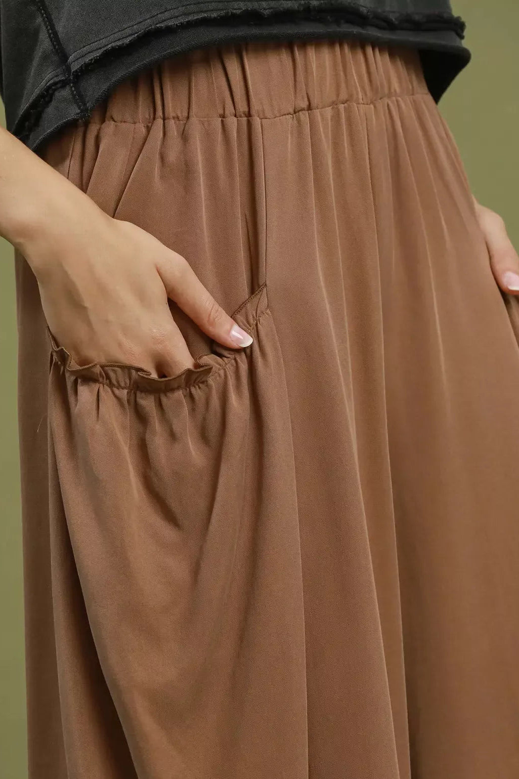 Brown pocket pants close-up, elastic waist and gathered details