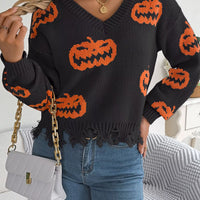 Black knit V-neck pumpkin sweater with orange jack-o’-lantern motifs and distressed fringe hem