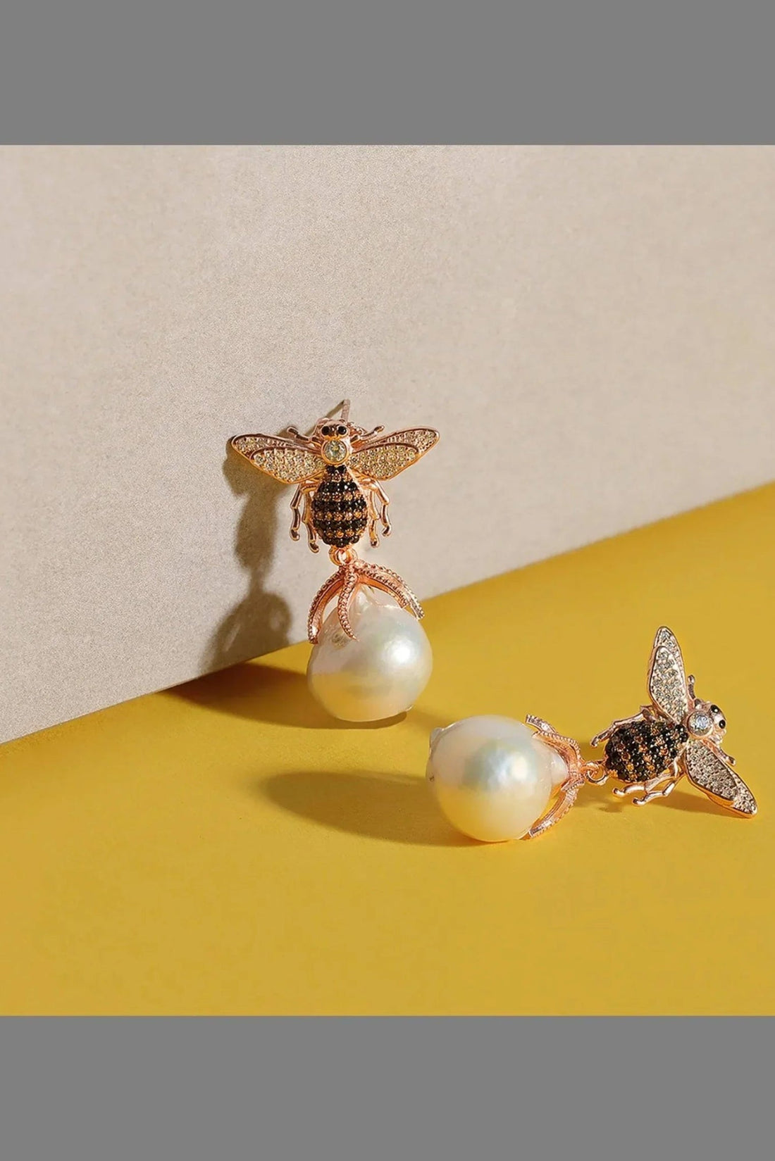 Gold-tone bee drop earrings with crystal wings and white pearl dangles