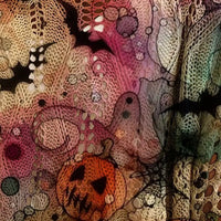 Plus size loose knit cover-up close-up with pink and purple Halloween print and orange pumpkin details.