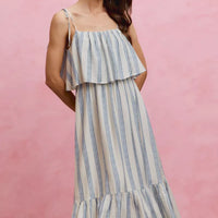 Sleeveless blue-and-white striped midi dress with tie shoulder straps and tiered skirt ruffles