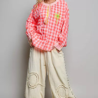 Pink gingham embroidered blouse with long sleeves and palm tree front, paired with pants