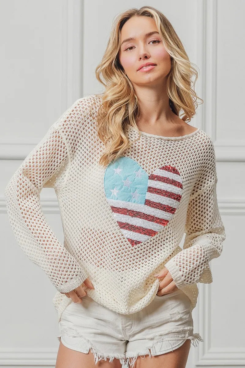 Off-white sequin knit sweater with American flag heart design, long sleeves.